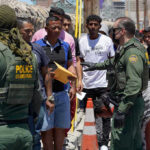 Protests Erupt After Fatal ICE Shooting Border patrol agents inspecting group of individuals in line.
