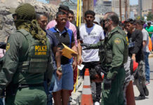 Protests Erupt After Fatal ICE Shooting Border patrol agents inspecting group of individuals in line.