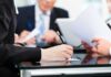 CNBC Praise, Million-Dollar Moves — Then Boom Close-up of a hand writing notes during a business meeting