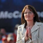 A female politician clapping at a political rally