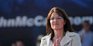 A female politician clapping at a political rally