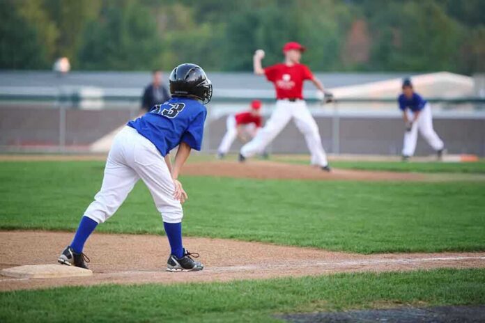 Young baseball player in blue uniform preparing to run on the field