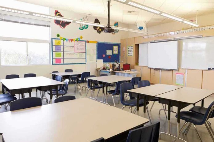 shutterstock_388578202 Empty classroom with tables, chairs, and a whiteboard
