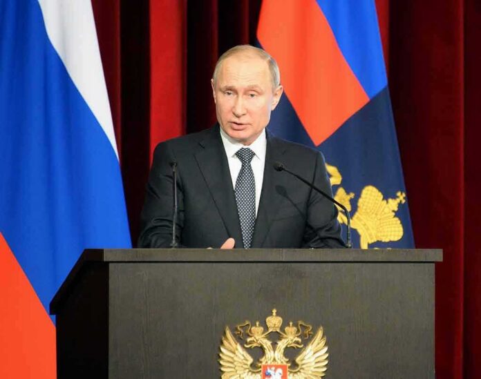 shutterstock_1038561886 Vladimir Putin speaking at a podium with microphones