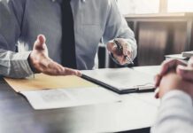 Schools and Agencies Face $400M Legal Claim Business meeting with two people reviewing a document on a clipboard