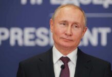 man in suit speaking at a podium