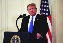 Caribbean Ambassador Nomination Moves Forward man at podium with microphone and US flag
