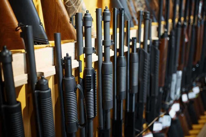 shutterstock_1668328999 Shotguns and rifles lined up on a rack in a gun store