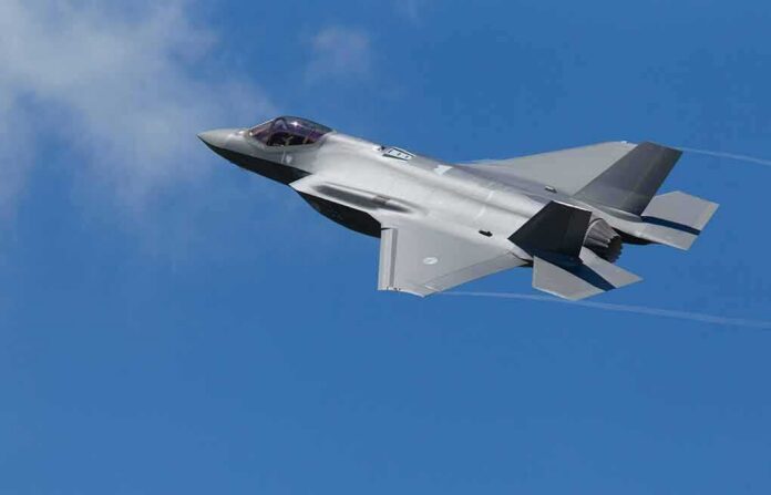 shutterstock_1803194377-1 Stealth fighter jet banking in a clear blue sky