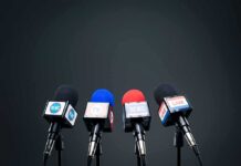 Viral Warning: Hate Is America’s Real Virus Four broadcast microphones on stands against a dark background