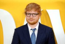 Sheeran Speaks Out on Gaza Ed Sheeran in a navy suit against a yellow backdrop