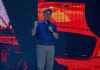 man giving a talk on stage with microphone