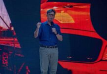 man giving a talk on stage with microphone