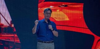man giving a talk on stage with microphone