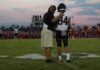 68-Game Streak Ends on a Last-Minute Score football coach with arm around player number 84 on sideline