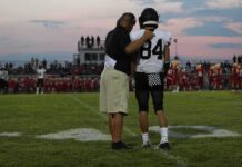 68-Game Streak Ends on a Last-Minute Score football coach with arm around player number 84 on sideline