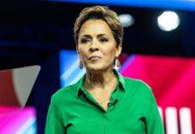 Woman speaking on stage in a green shirt