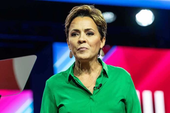 shutterstock_2271201441 Woman speaking on stage in a green shirt