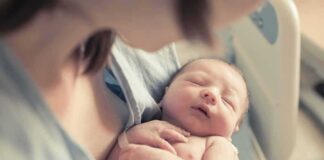 newborn baby sleeping in a parent's arms