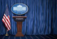 New White House Press Secretary Makes Fox Connection Clear White House press briefing podium with U.S. flag and blue curtain