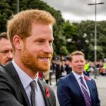 Prince Harry, Duke of Sussex greets people at an outdoor event