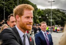 Prince Harry, Duke of Sussex greets people at an outdoor event