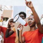 Michigan Senate Race Turns to Faith and Fear Protester with megaphone leading a crowd