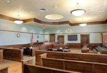 Murder Trial Faces Major Delay Empty courtroom with wooden benches and judge's bench