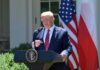 Donald Trump speaking at a podium with U.S. and Polish flags behind him
