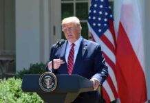 Trump to Voters: “Vote Like I’m on the Ballot” Donald Trump speaking at a podium with U.S. and Polish flags behind him