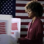 Texas Senate Candidate Pushes Back on Health Rumors Voter at a polling booth with an American flag backdrop