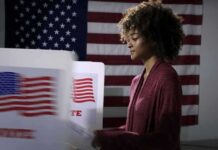 Texas Senate Candidate Pushes Back on Health Rumors Voter at a polling booth with an American flag backdrop