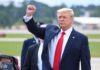 Trump Hints at Possible Kim Jong Un Summit man in suit raising a clenched fist outdoors