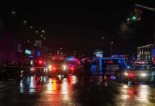 Australian MP Critically Injured in Suspected Deliberate Car Attack Nighttime police scene with flashing lights on a wet city street