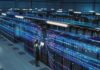 UK Reports Hundreds of Critical Infrastructure Attacks Technician with laptop in a large data center aisle