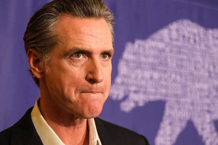 shutterstock_2368126823 Gavin Newsom at a press event with a purple backdrop