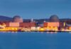 nuclear power plant with two domed reactor buildings by water at dusk