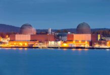 America’s Largest Nuclear Site Proposed nuclear power plant with two domed reactor buildings by water at dusk