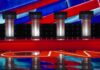 Race Bombshell Ignites California Debate Debate stage with four empty podiums and bright red and blue backdrop
