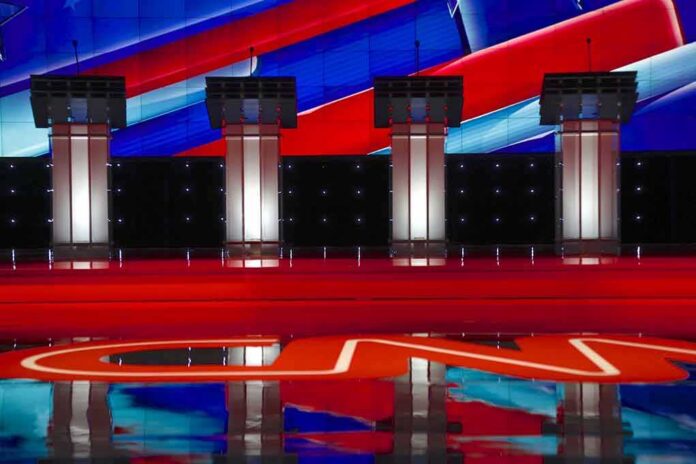Debate stage with four empty podiums and bright red and blue backdrop