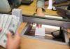 Suspect Accused of Robbing Two Banks Bank teller hands receipt through service window