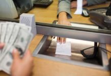 Suspect Accused of Robbing Two Banks Bank teller hands receipt through service window