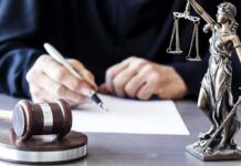 DNA Reports Add New Twist to Omar Investigation Judge writing at desk with gavel and Lady Justice statue