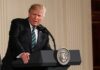 Donald Trump speaking at a podium with presidential seal