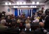 Five-Day Tenure Shakes Up White House Press Office Press secretary at podium addressing reporters in briefing room